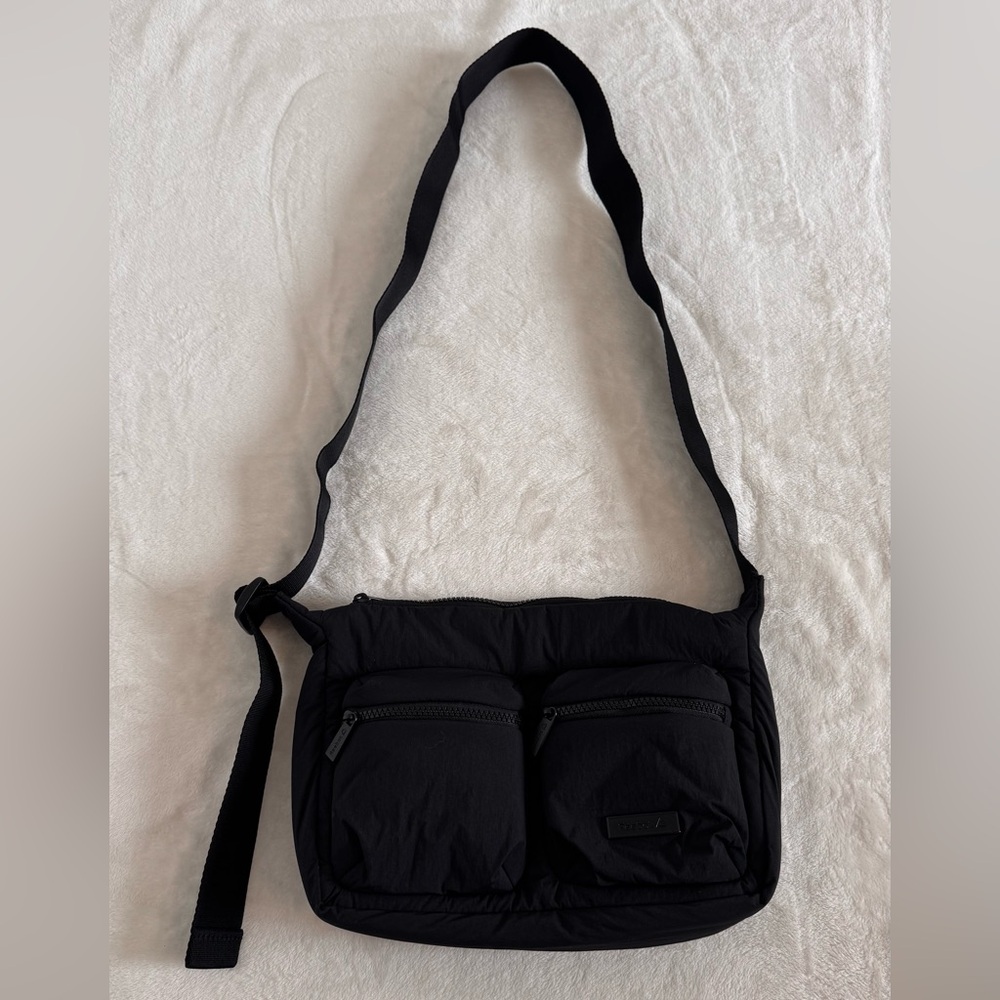 Reebok black puffy nylon bag with adjustable strap. 2 front zippered pockets.
